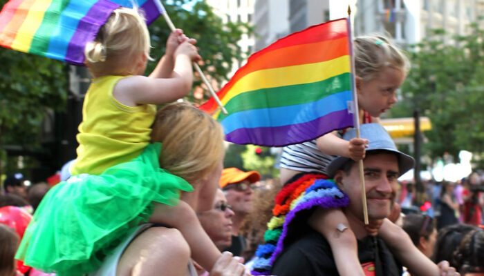A family from our congregation waving rainbow flags at the Pride Parade